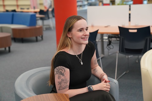 Liz Van Bakel sitting in a chair in the CNC Library