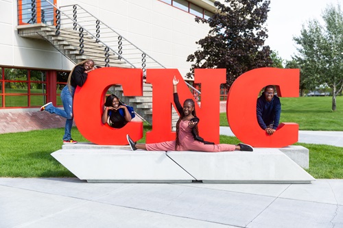 Students posing on CNC sign