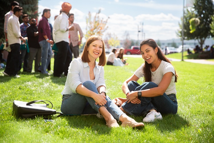 Happy students sitting on the grass