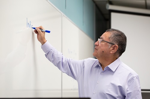 Professor writing on a whiteboard