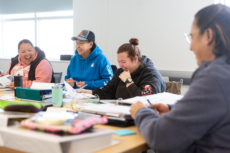 4 students laughing together in class