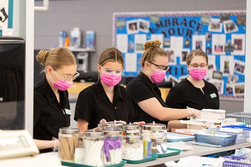 Dental assistant students organizing equipment