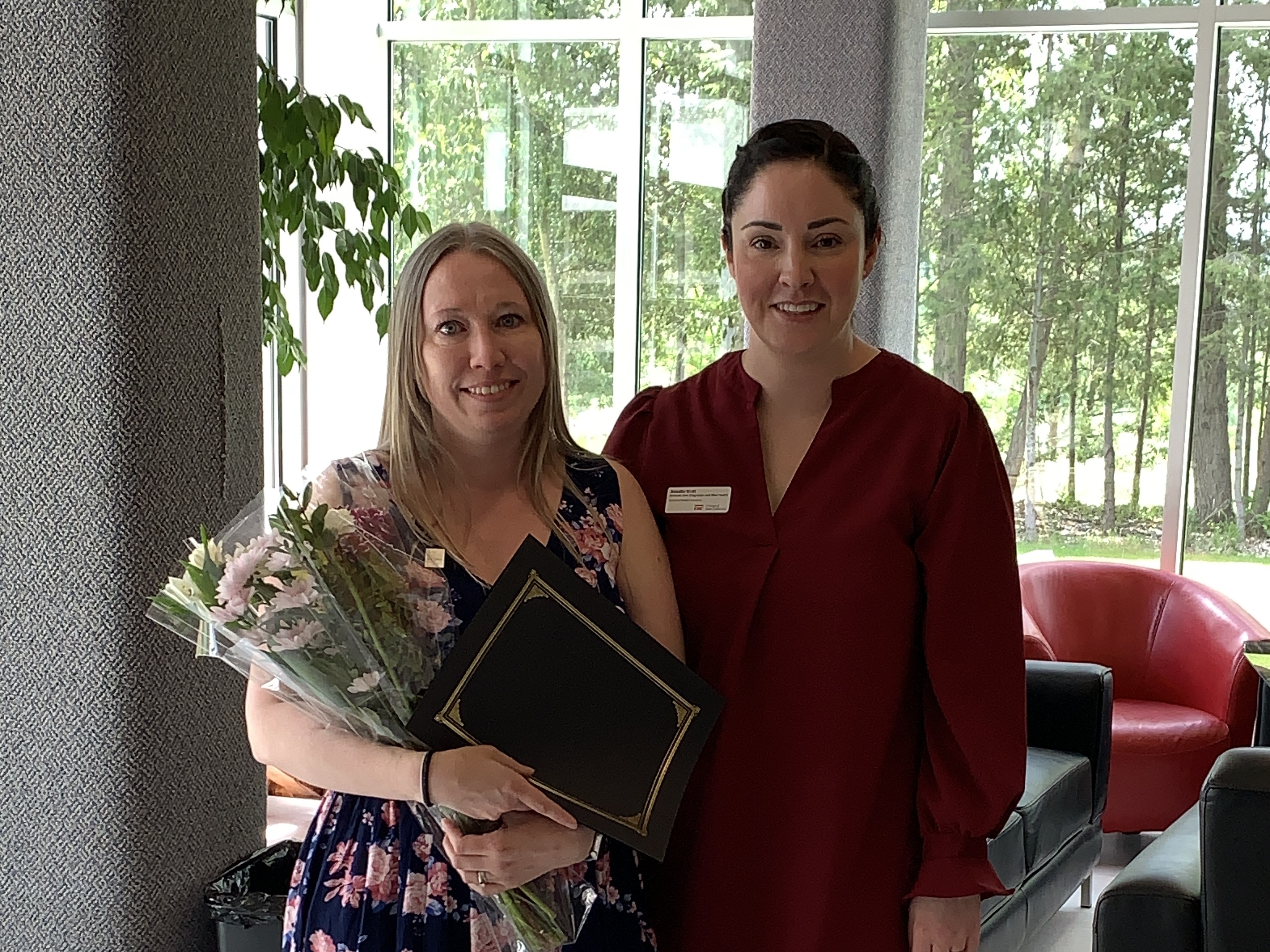 Stephanie Monfort holding flowers and diploma