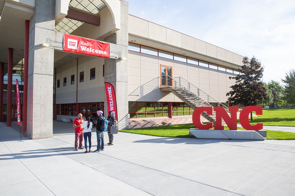 New students standing by CNC sign