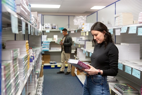 Student picking out a book in the bookstore