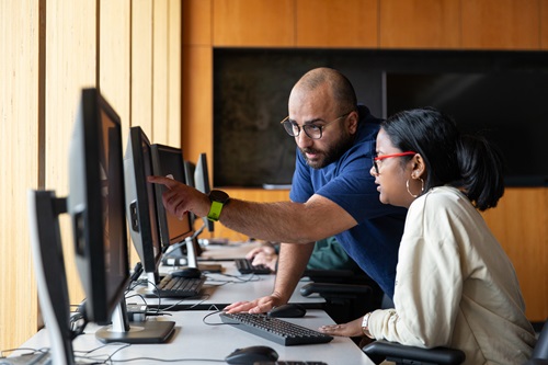 Prof helping student on a computer