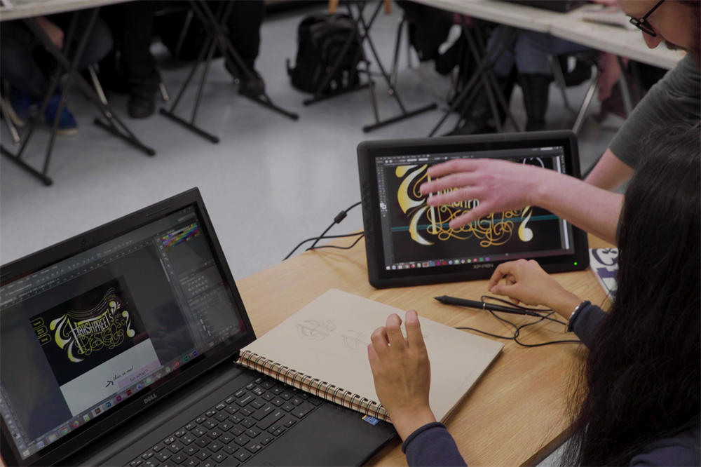 Instructor helps a student with her typography assignment