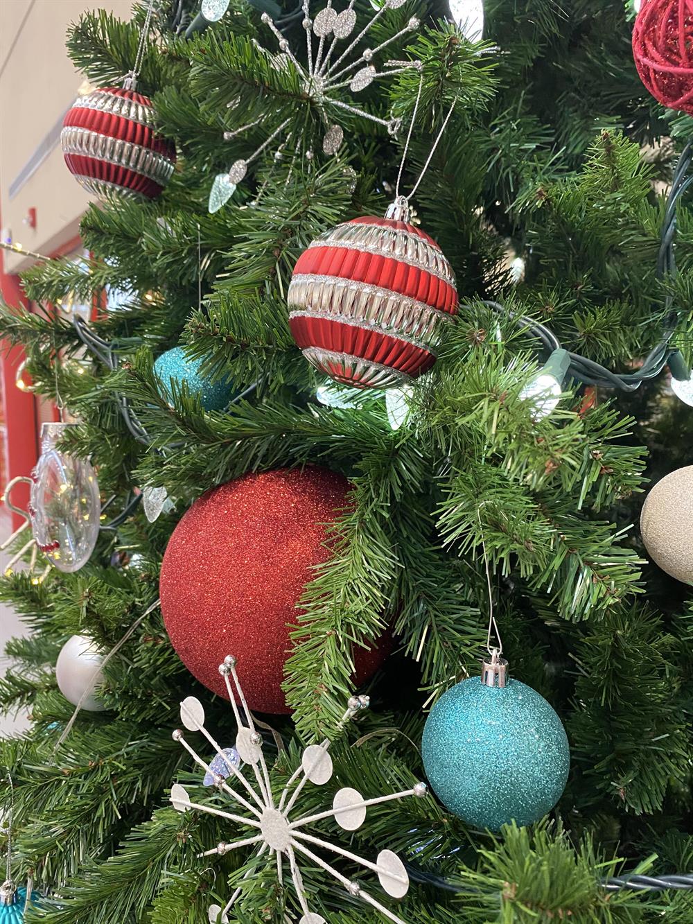 Closeup of Christmas tree with red and teal ornaments