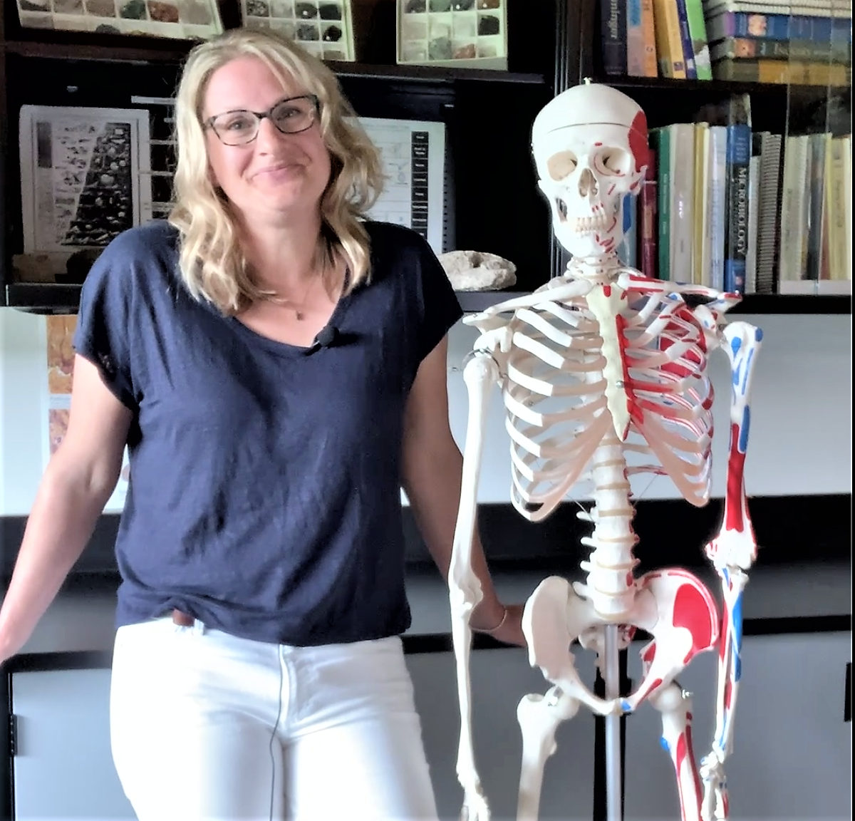 Jennifer Catherall, biology instructor at CNC stands next to a skeleton model