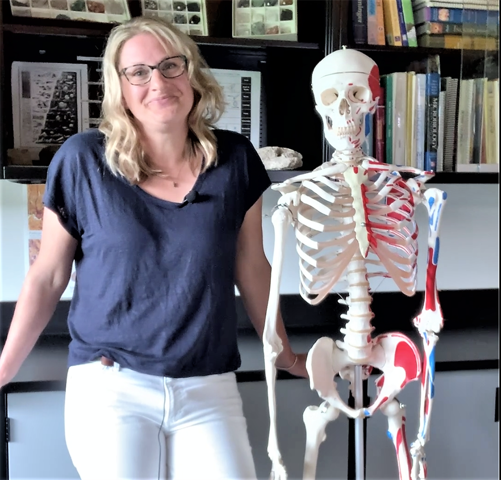 Jennifer Catherall, biology instructor at CNC stands next to a skeleton model