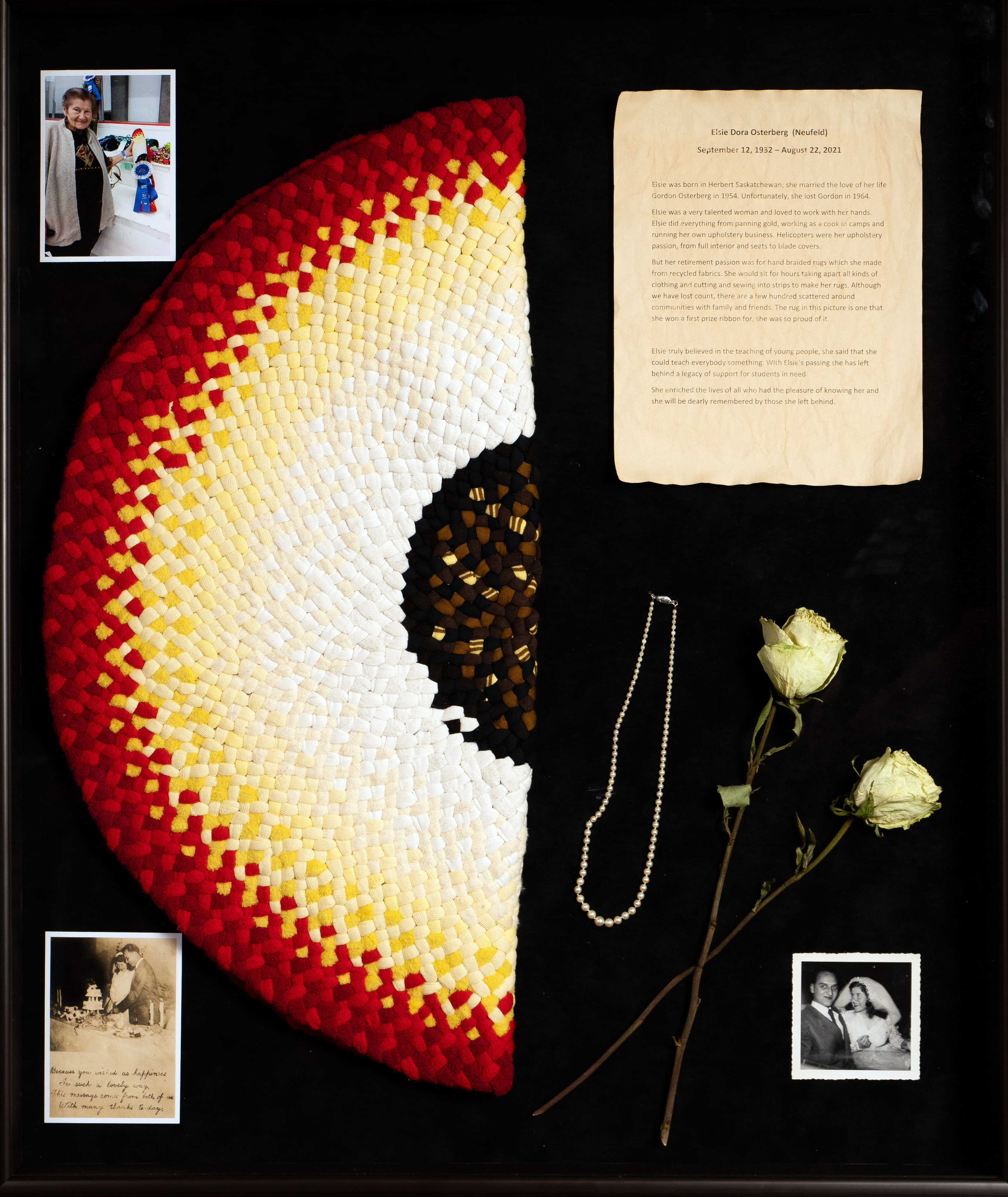 Elsie Osterberg Display: Hand-woven colourful rug, pearl necklac, white roses, photos throughout her life